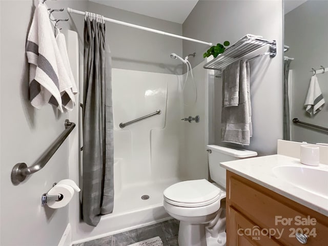 bathroom with tile patterned flooring, vanity, curtained shower, and toilet