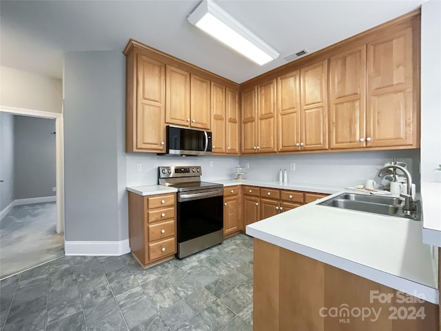 kitchen featuring kitchen peninsula, appliances with stainless steel finishes, and sink