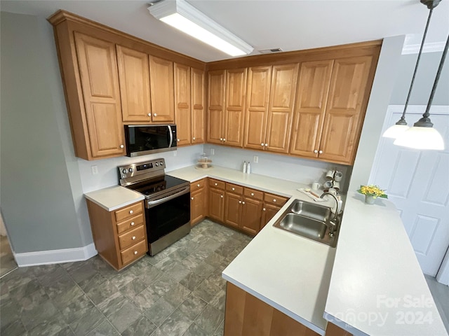 kitchen featuring hanging light fixtures, sink, and appliances with stainless steel finishes