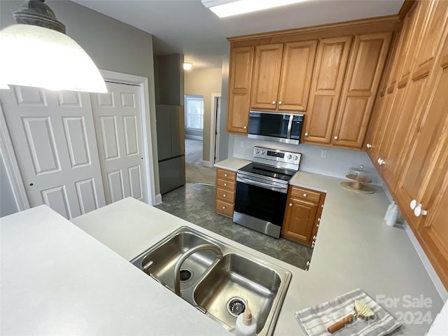 kitchen featuring pendant lighting, stainless steel appliances, and sink