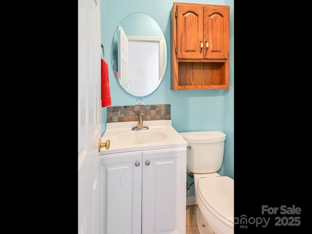 bathroom with tile patterned flooring, vanity, and toilet