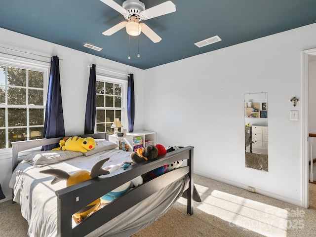 bedroom featuring multiple windows, ceiling fan, and light colored carpet