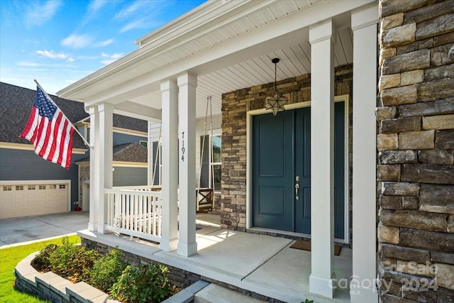 doorway to property featuring a garage and covered porch