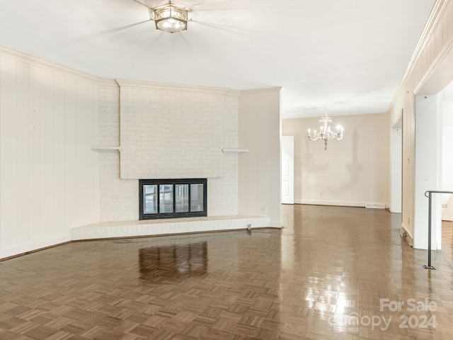 unfurnished living room featuring dark parquet flooring, a fireplace, and an inviting chandelier