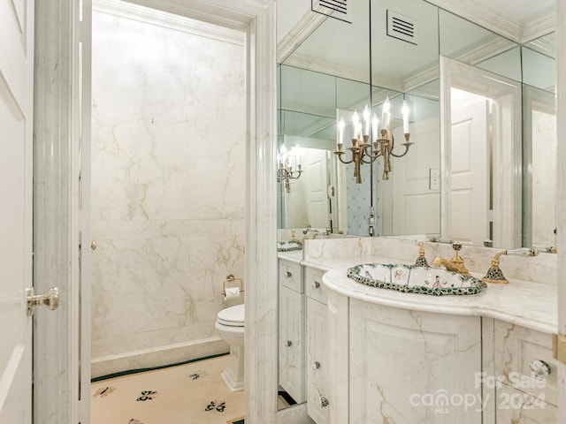 bathroom featuring vanity, an inviting chandelier, toilet, ornamental molding, and tile walls