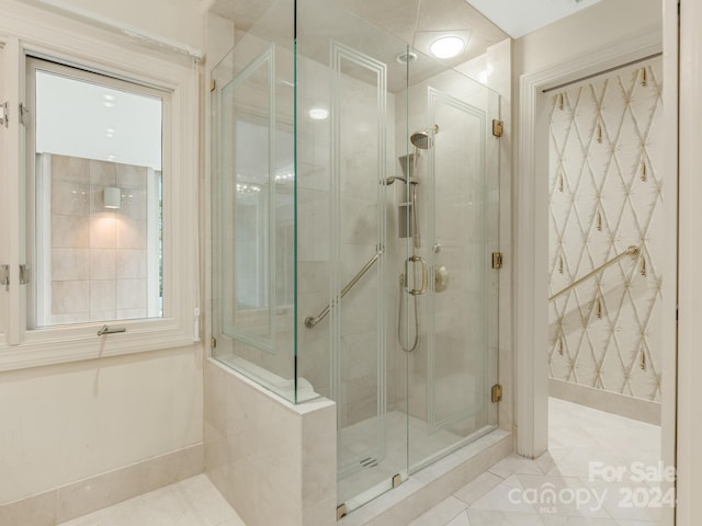 bathroom with tile patterned floors and a shower with door