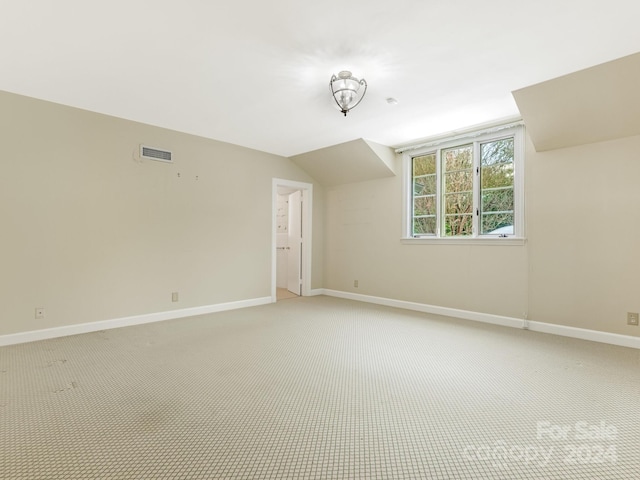 additional living space featuring light colored carpet