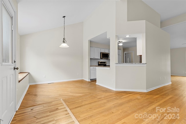 kitchen with white cabinets, hanging light fixtures, light hardwood / wood-style flooring, and appliances with stainless steel finishes