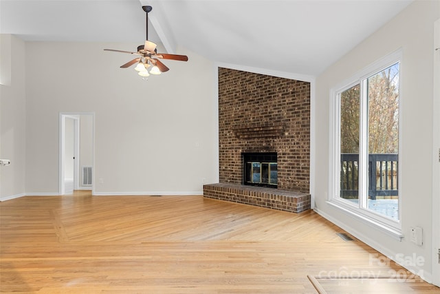 unfurnished living room featuring light wood-type flooring, ceiling fan, vaulted ceiling with beams, and a fireplace