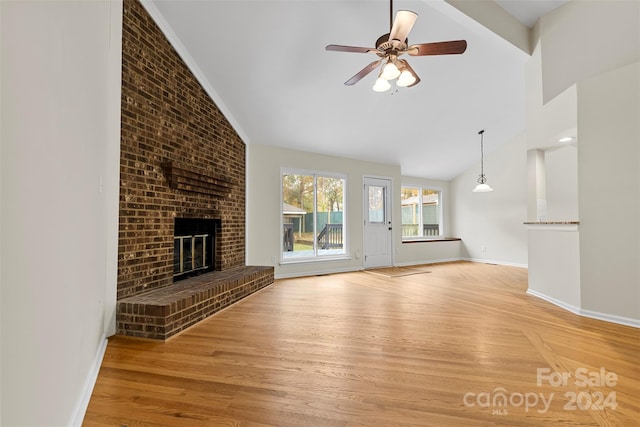 unfurnished living room with ceiling fan, lofted ceiling, light hardwood / wood-style floors, and a brick fireplace