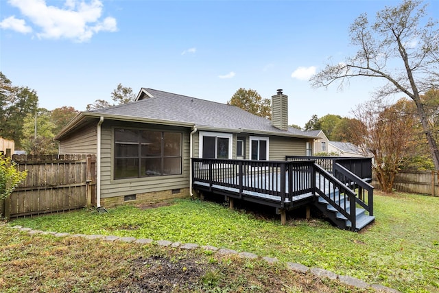 back of property with a yard and a wooden deck