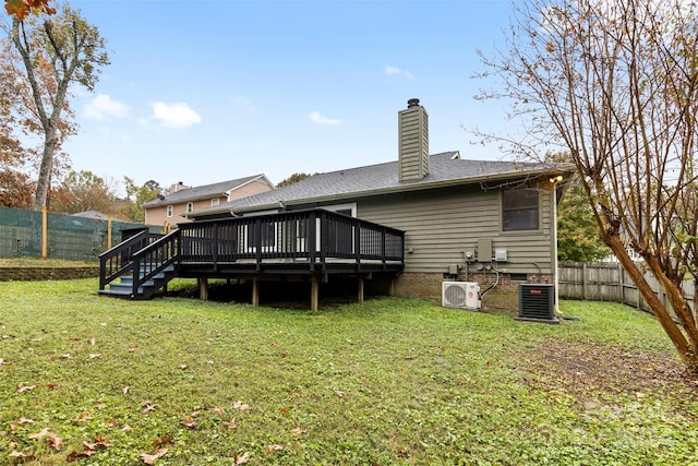 rear view of property with central AC unit, a wooden deck, and a yard