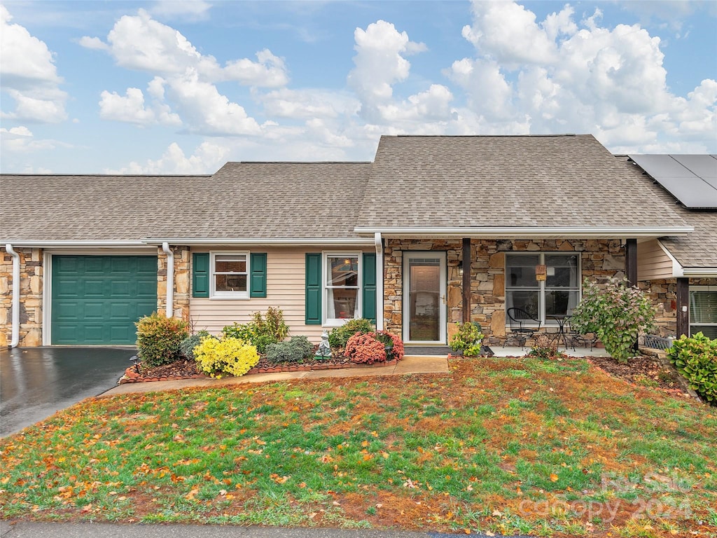 ranch-style home featuring a garage and a front yard