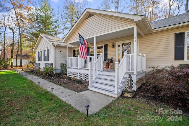 bungalow with a porch and a front lawn