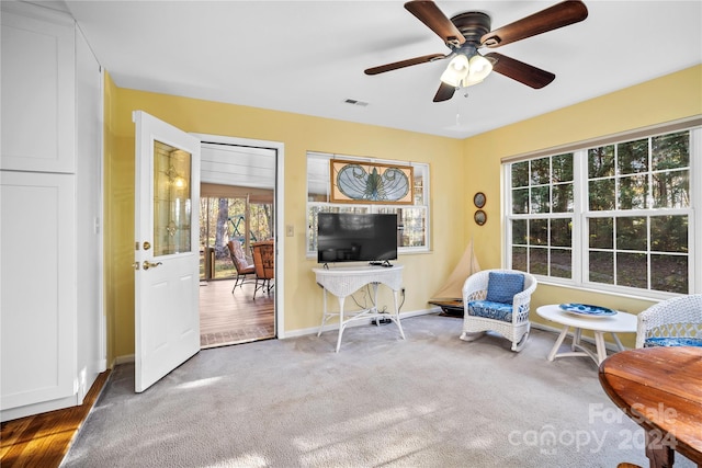 living area with hardwood / wood-style floors and ceiling fan