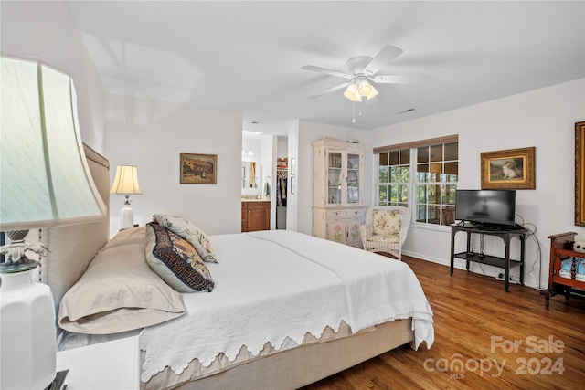 bedroom featuring hardwood / wood-style flooring, ceiling fan, and ensuite bath