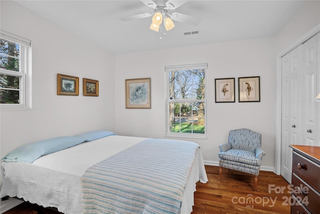 bedroom with ceiling fan, dark hardwood / wood-style floors, and a closet