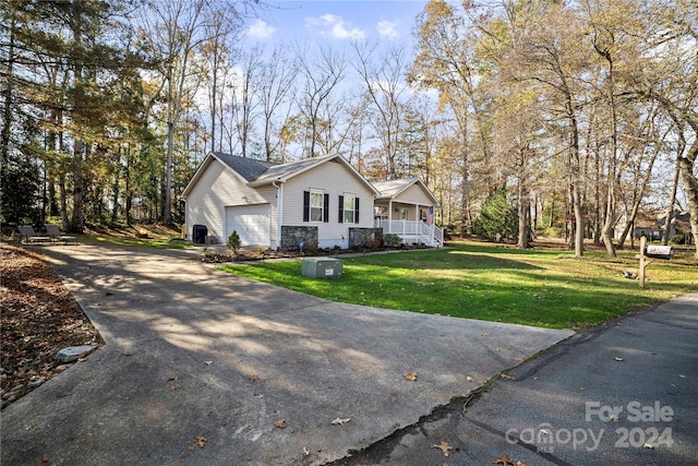 view of side of property featuring a garage, a yard, and a porch