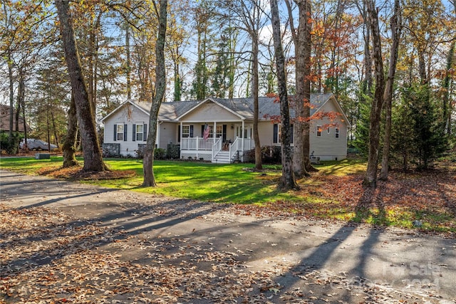 ranch-style house featuring a front lawn and covered porch