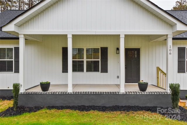 view of exterior entry featuring covered porch