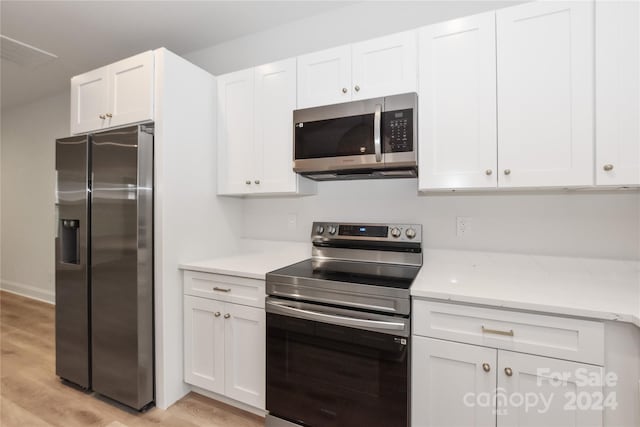 kitchen featuring white cabinetry, stainless steel appliances, and light wood-type flooring