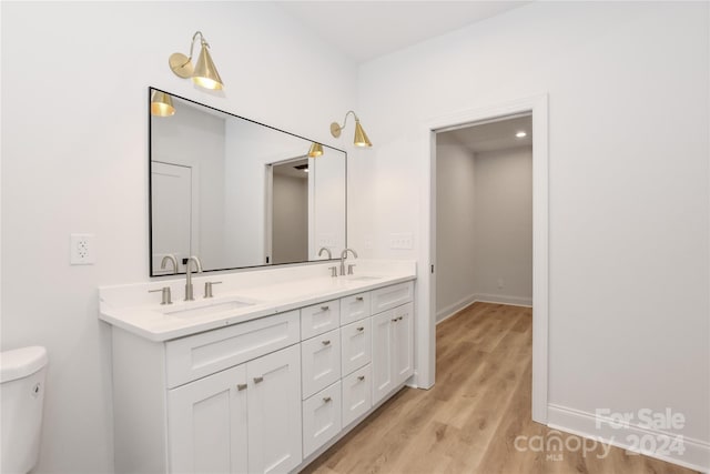 bathroom with hardwood / wood-style floors, vanity, and toilet