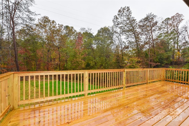 wooden terrace featuring a lawn