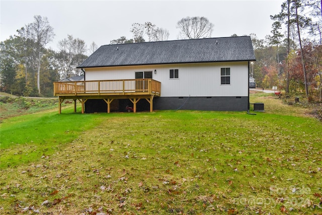 back of property featuring central air condition unit, a wooden deck, and a yard