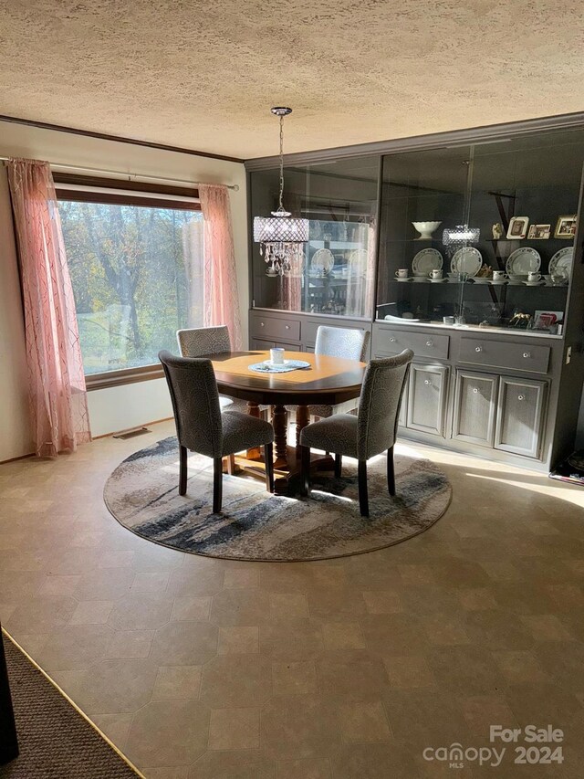 dining area with a notable chandelier and a textured ceiling