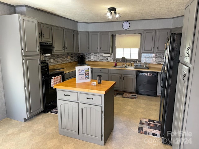 kitchen featuring black appliances, wooden counters, a textured ceiling, gray cabinets, and sink