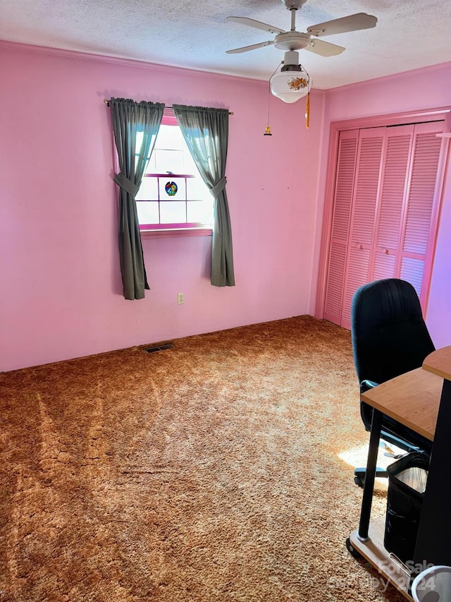 unfurnished office with ceiling fan, a textured ceiling, and carpet floors