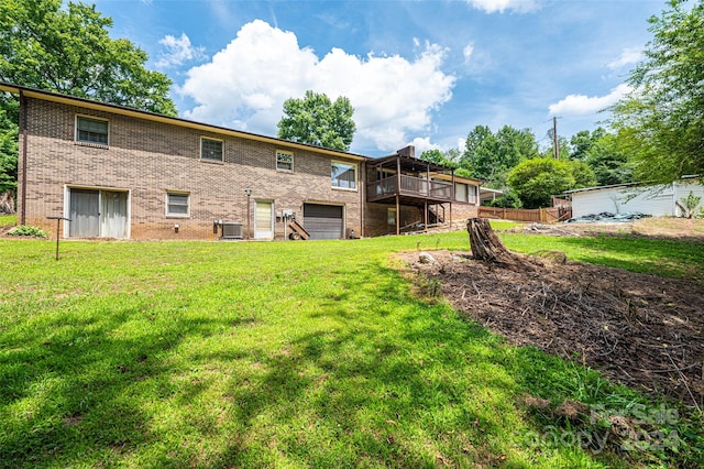 back of house featuring a lawn, central air condition unit, and a wooden deck