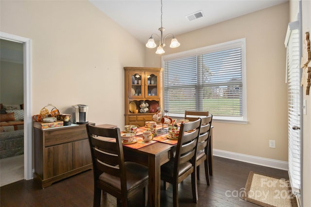 dining space with a chandelier, vaulted ceiling, and dark hardwood / wood-style floors