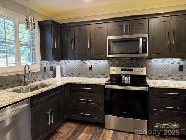 kitchen with appliances with stainless steel finishes, dark brown cabinetry, decorative backsplash, and sink