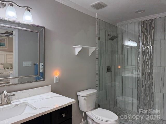 bathroom with toilet, ornamental molding, walk in shower, and vanity