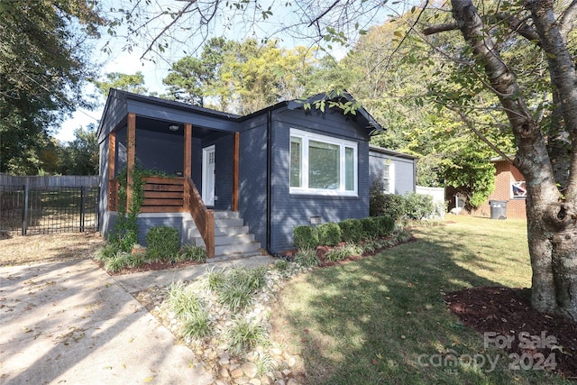 view of front of home with a porch and a front lawn