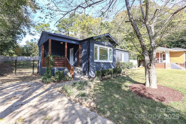 view of front of home with a porch, a front yard, brick siding, and fence