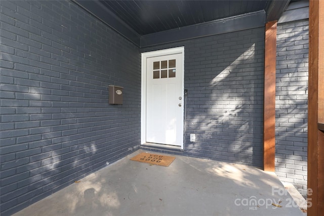 property entrance featuring brick siding