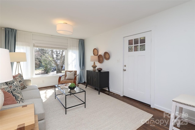 living room with baseboards and dark wood-style flooring