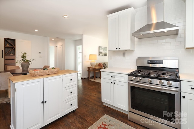 kitchen featuring stainless steel range with gas cooktop, white cabinets, light countertops, and wall chimney exhaust hood