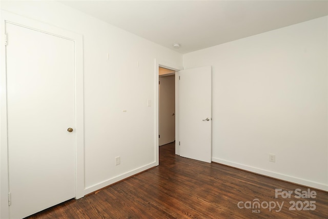 unfurnished bedroom featuring dark wood-style flooring and baseboards