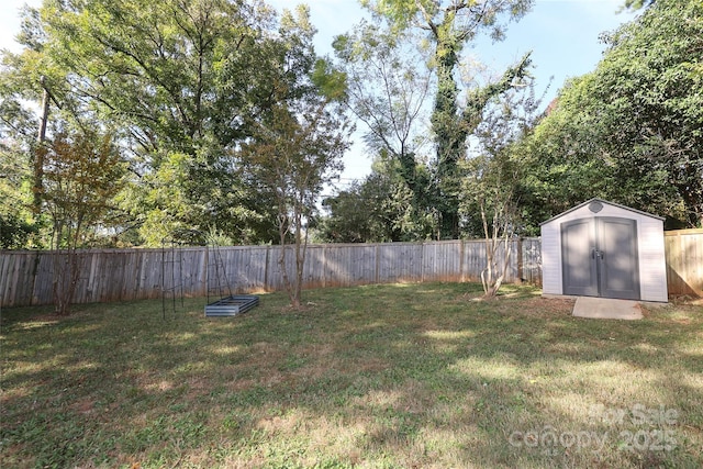 view of yard with a storage shed, a fenced backyard, and an outbuilding