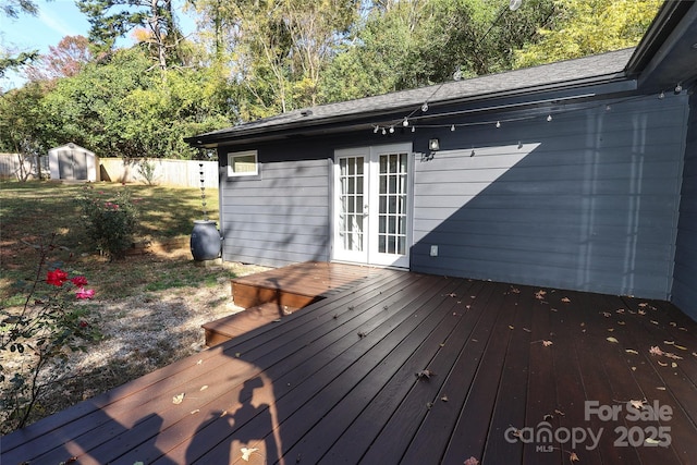 deck with an outbuilding, french doors, fence, and a shed