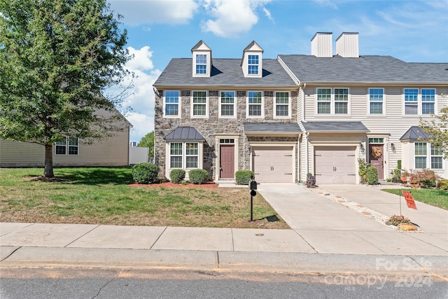 view of front of home featuring a garage and a front yard