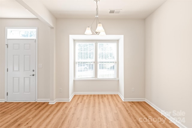 foyer entrance featuring a chandelier and light hardwood / wood-style flooring