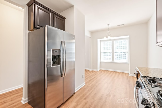 kitchen featuring dark brown cabinetry, appliances with stainless steel finishes, light hardwood / wood-style flooring, a notable chandelier, and pendant lighting