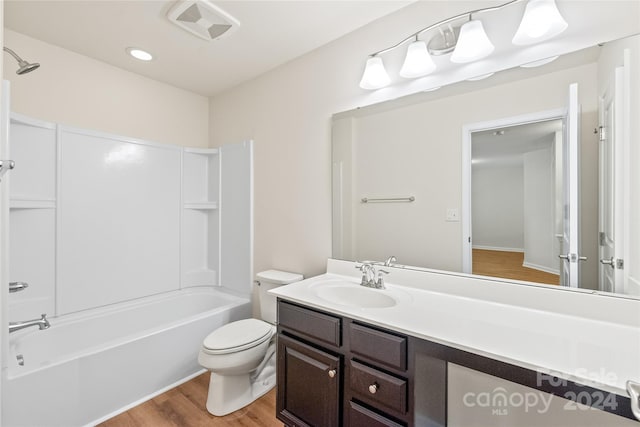 full bathroom with toilet, vanity, hardwood / wood-style floors, and shower / washtub combination