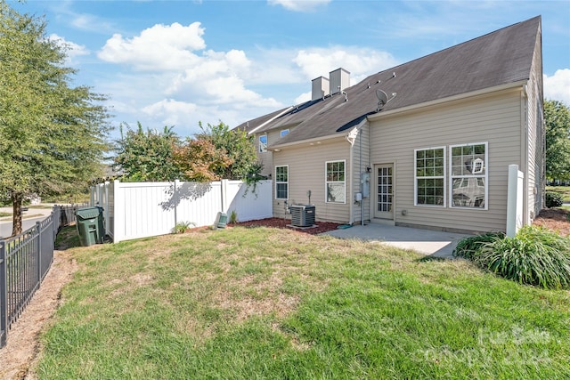 rear view of property featuring central AC unit, a patio, and a yard