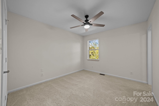 carpeted empty room featuring ceiling fan