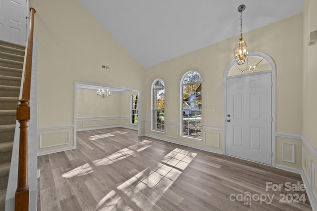 foyer with a chandelier, high vaulted ceiling, and light hardwood / wood-style flooring